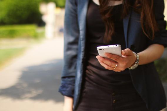 Eine junge Frau hält ein Smartphone in der Hand