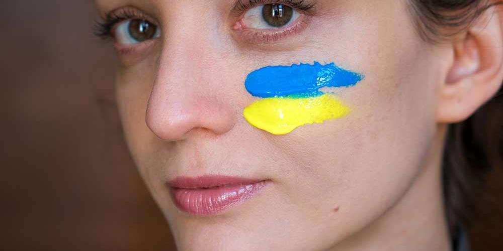 Mädchen mit ukrainischer Fahne auf der Wange aufgemalt