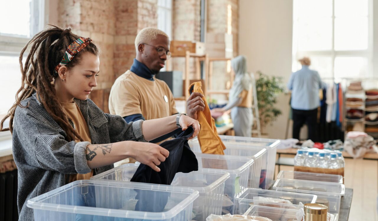 Zwei Jugendliche beim Sortieren von Kleidung