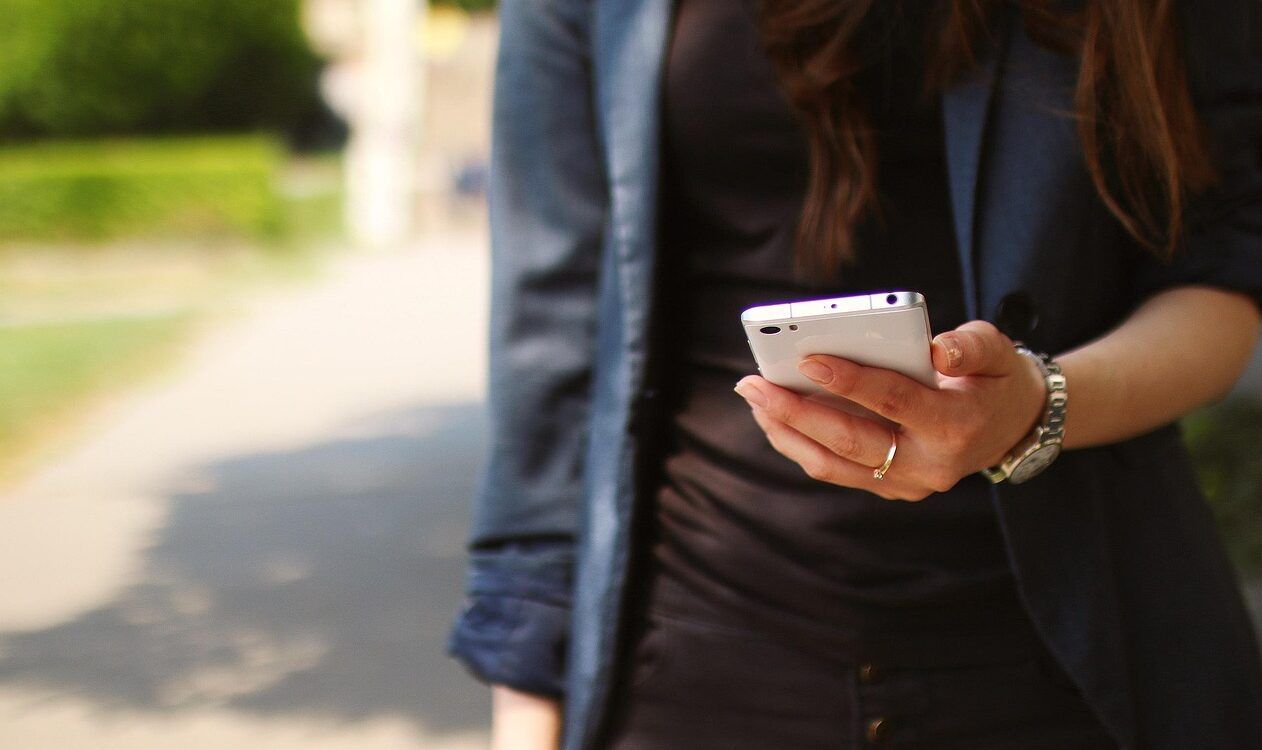 Junge Frau hält Handy in der Hand