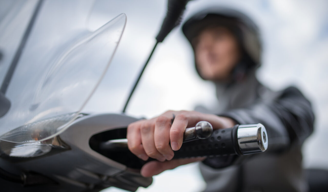 Eine junge Frau fährt mit einem E-Moped.